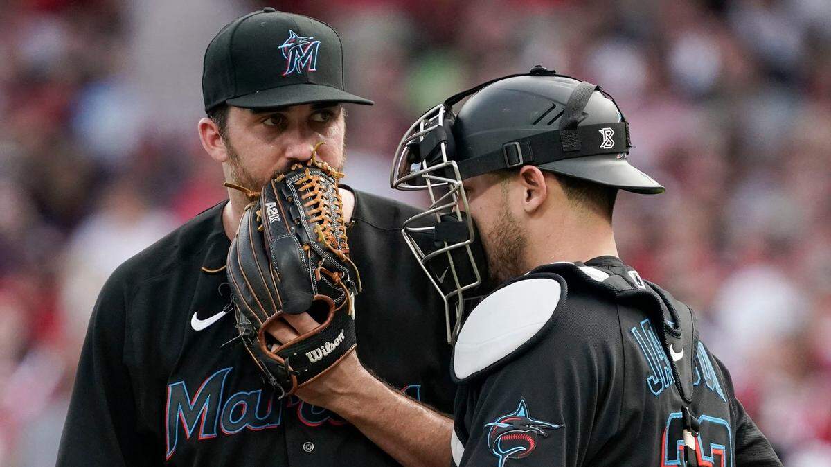 Miami Marlins starting pitcher Zach Thompson, left, speaks with catcher Alex Jackson during the first inning of a baseball game against the Cincinnati Reds, Saturday, Aug. 21, 2021, in Cincinnati. (AP Photo/Jeff Dean)