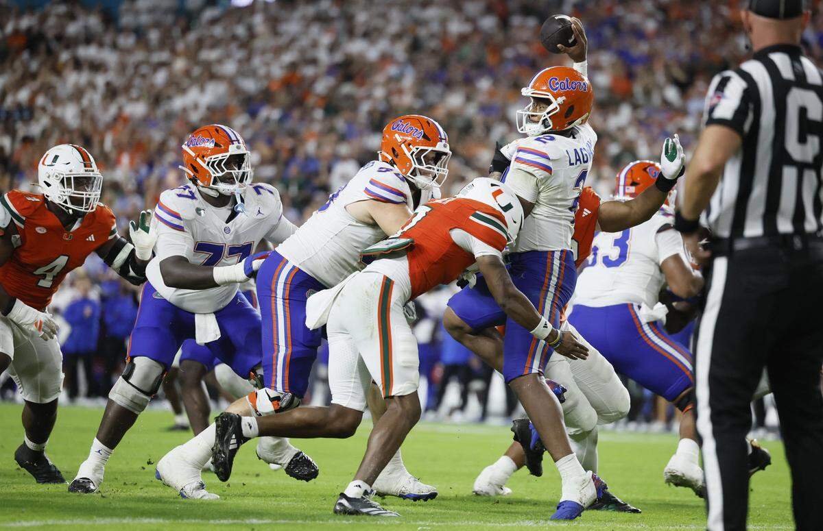 Miami Hurricanes defensive back Zechariah Poyser sacks Florida Gators quarterback DJ Lagway in first half action.