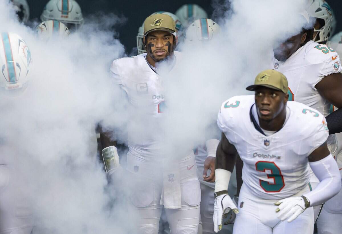 Miami Dolphins quarterback Tua Tagovailoa (1) runs on the field with his teammates before playing against the Buffalo Bills in their NFL game at Hard Rock Stadium on Sunday, Nov. 9, 2025, in Miami Gardens, Fla.