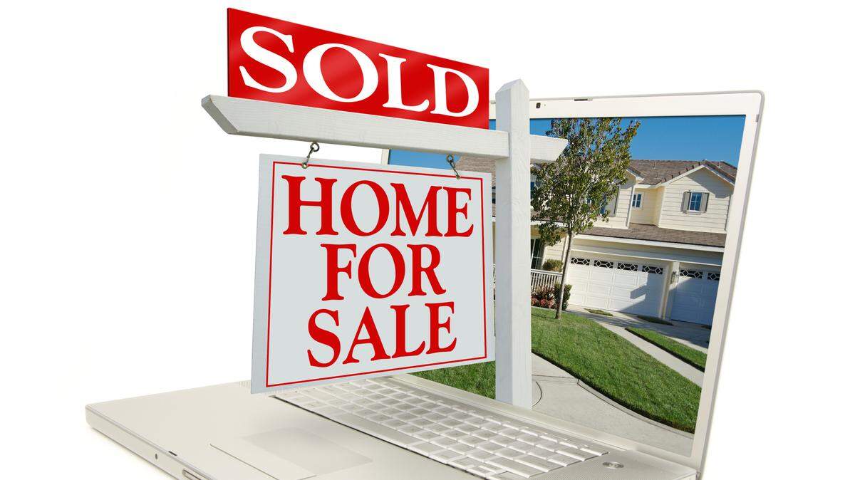 Sold Home for Sale Sign & New Home on Laptop isolated on a white Background.