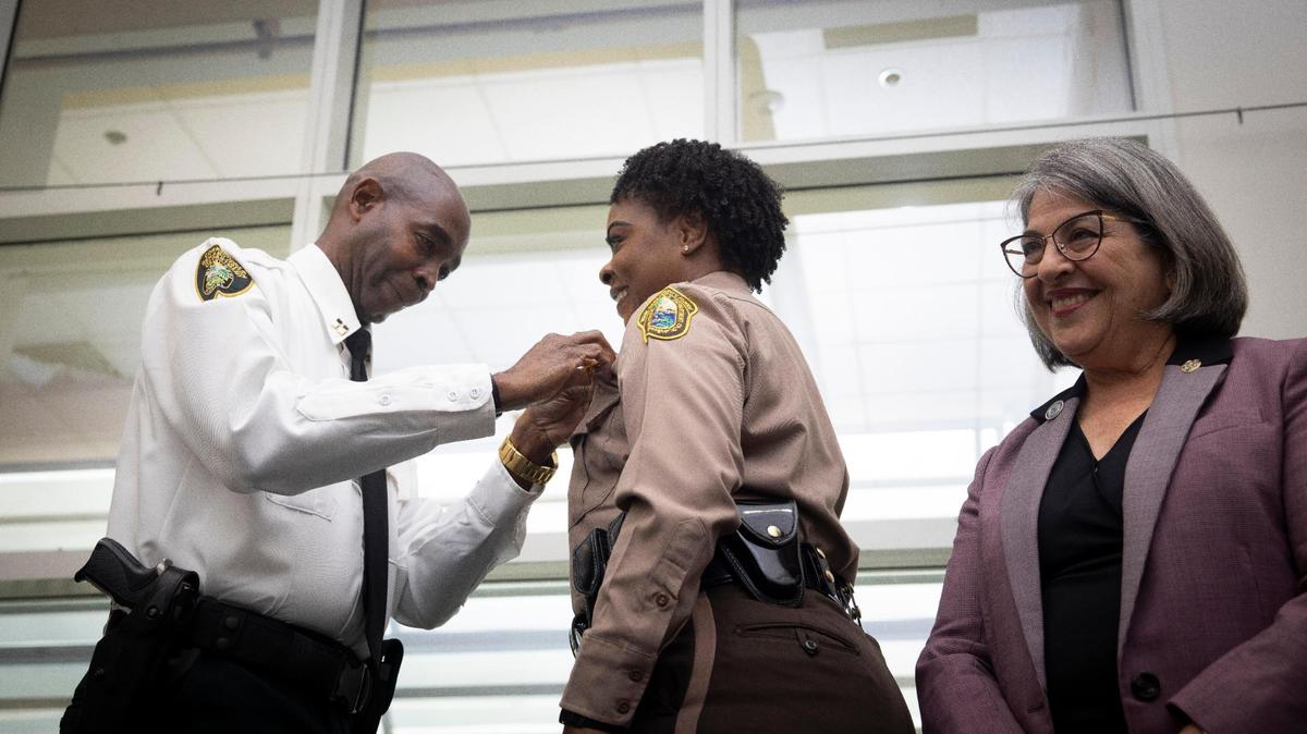 Miami-Dade Police Director Stephanie V. Daniels, center, gets her director badge pinned to her uniform by her husband, Capt. Desi Daniels of the Miami-Dade Corrections and Rehabilitation Department, during her investiture ceremony at PortMiami on Wednesday, Jan. 10, 2024. Miami-Dade Mayor Daniella Levine Cava, right, officially appointed Daniels to the position in November.