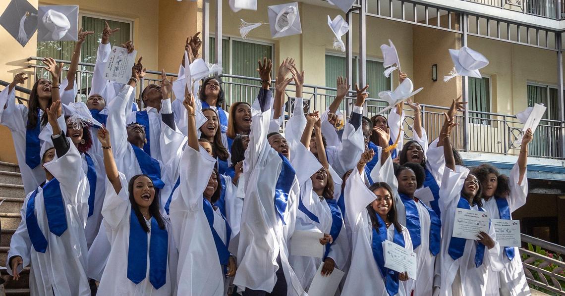 Graduates of Lycée Alexandre Dumas toss their caps in the air on June 23, 2022, as they celebrate their graduation at the Karibe Hotel in Petionville after spending their final year learning online.
