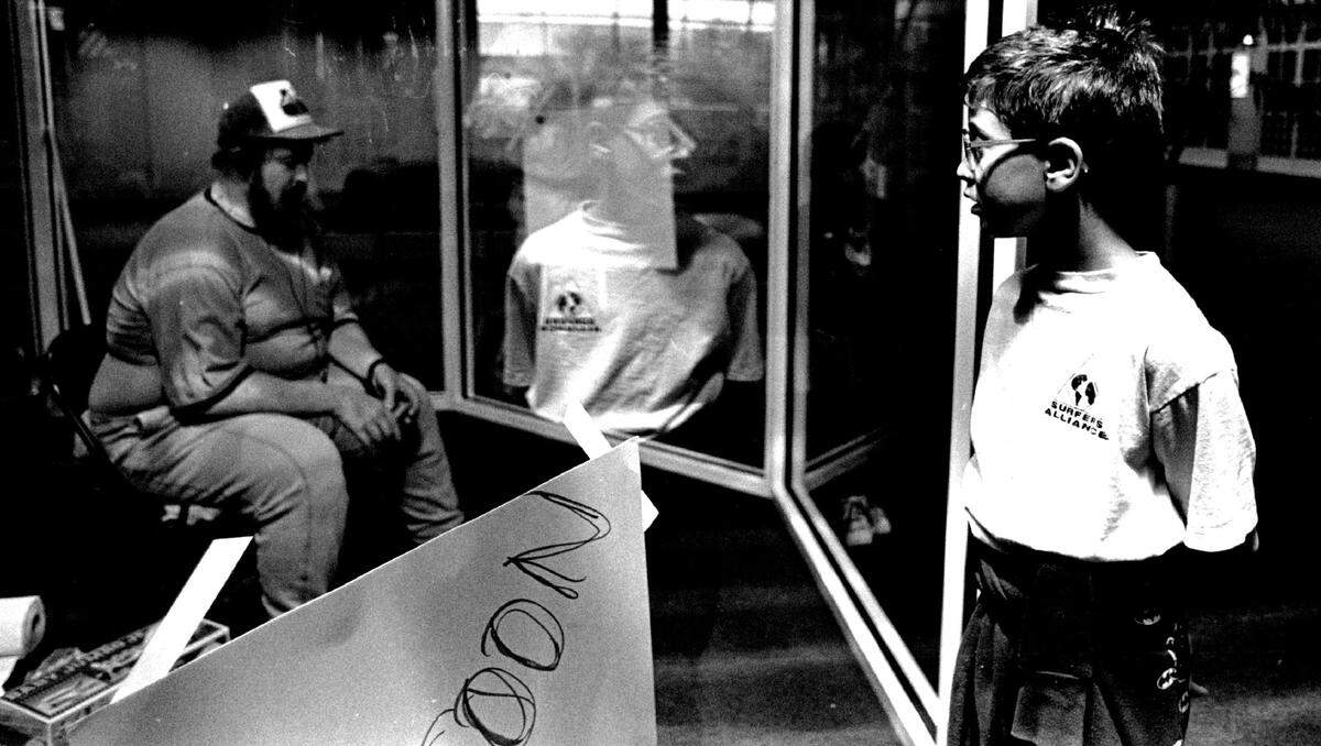 A young visitor stares in wonder at “The Vendor” as he tries to figure out if it is real or not at the Fort Lauderdale airport’s Terminal 2 in 1990.