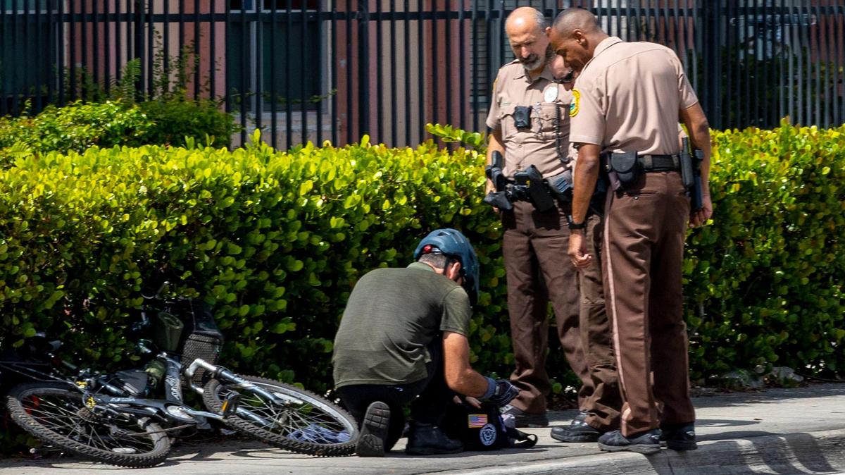 Miami-Dade Police officers interact with a suspicious bicyclist as they responded to a potential incident near Miami-Dade College Kendall Campus, that sent the campus into lockdown, in Miami, Florida, on Wednesday, August 17, 2022.