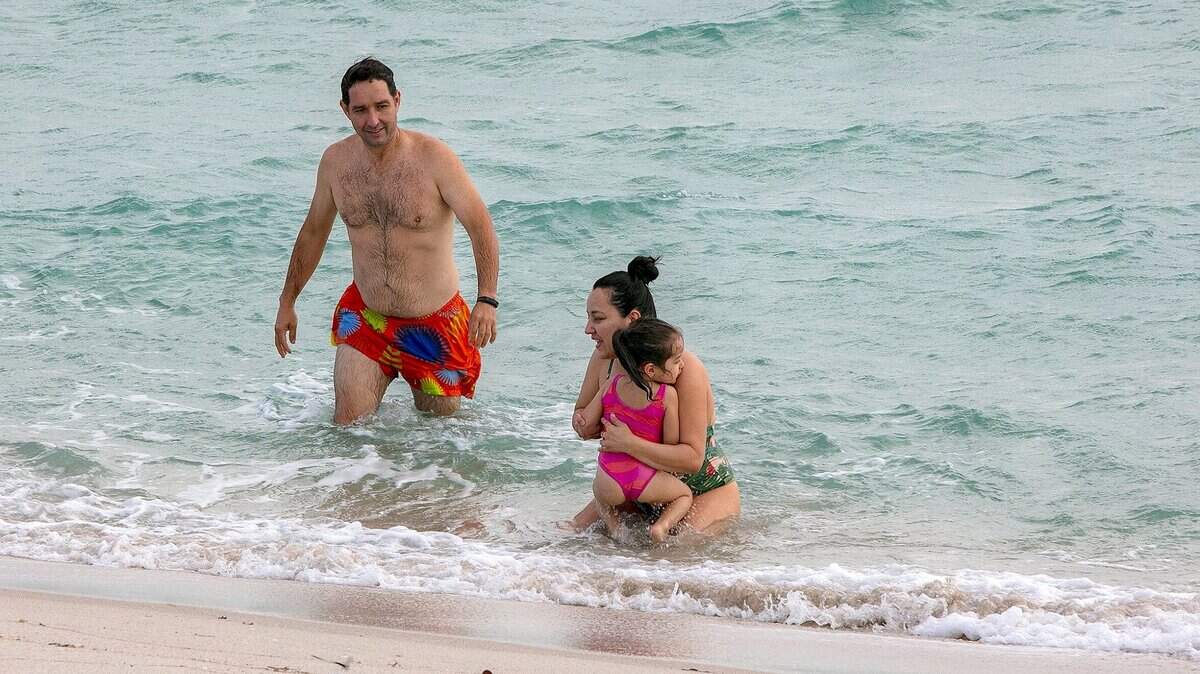A rip current warning says families such as Enrique Urueña and Carolina Cruz with their daughter Isabella Urueña, of Manizales, Colombia, here swimming off a Miami-Dade beach on Christmas Day, should be careful in the ocean waters from Miami-Dade to Palm Beach County Sunday and Monday.