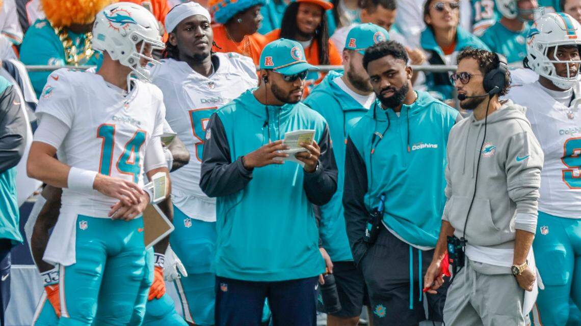 Miami Dolphins quarterback Tim Boyle (14) quarterback Tua Tagovailoa (1) running back Raheem Mostert (31) and  head coach Mike McDaniel on the sidelines in the first half during an NFL game against the Seattle Seahawks at Lumen Field in Seattle, Washington on Sunday, September 22, 2024. 
