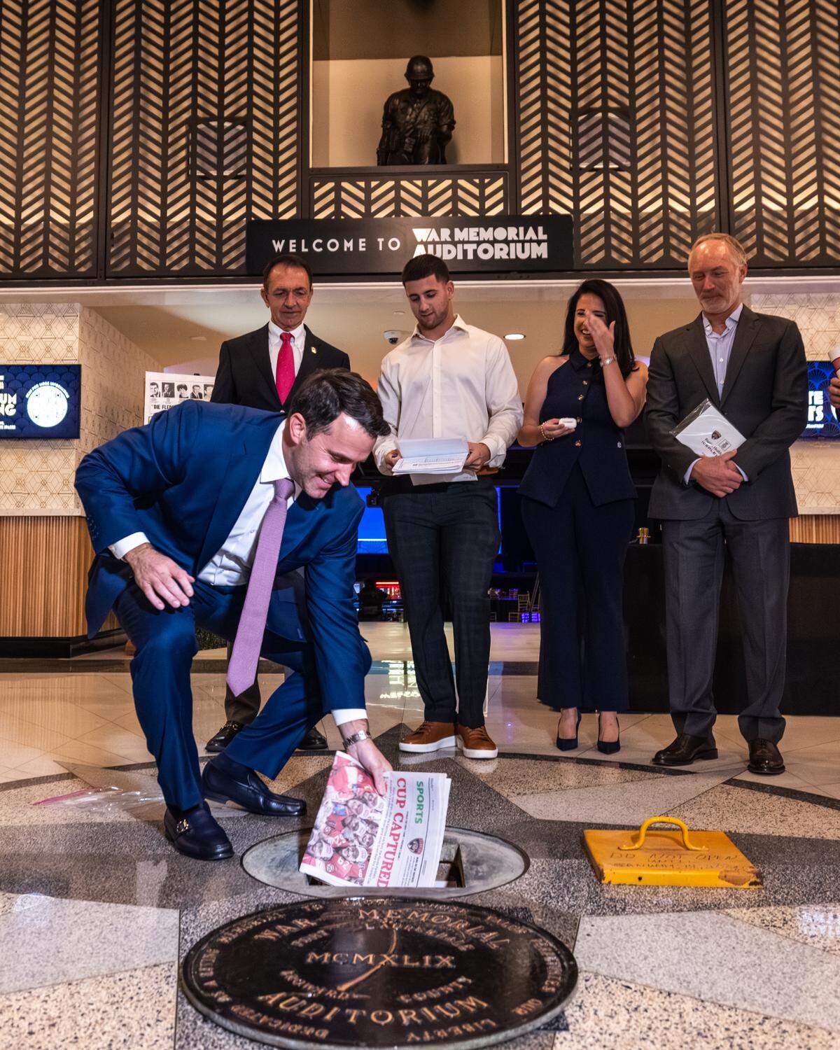 Panthers President & CEO Matt Caldwell putting a newspaper in the time capsule during the War Memorial Auditorium ribbon cutting ceremony on Nov. 13, 2024. From left to right, Fort Lauderdale Mayor Dean Trantalis, Basilio Fernandez of Lamartec, Live Nation’s Regional President of Florida, U.S. Concerts Brittany Flores and Matt Rossetti of Rossetti Architects were in attendence.