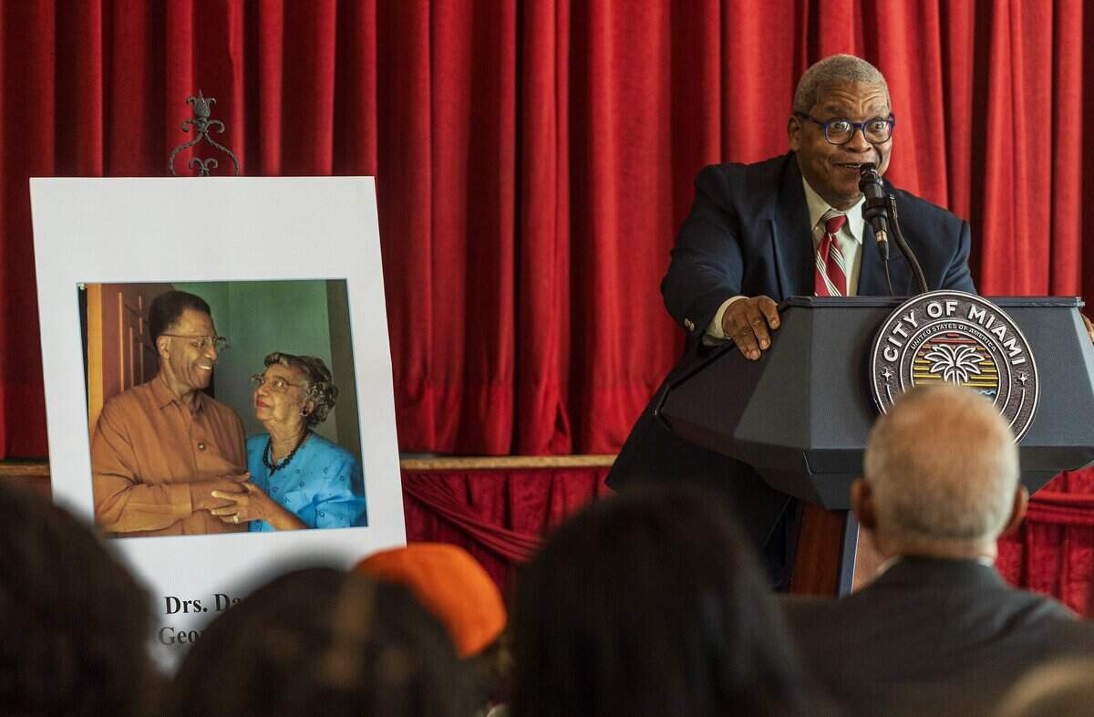 George Simpson Jr. speaks next to a picture of his parents during the street renaming ceremony to honor them, Florida’s first board certified Black pediatrician, Dazelle Simpson and her husband the state's first Black surgeon, George Simpson, celebrated at the Christ Episcopal Church, in Coconut Grove, on Friday, January 23, 2026.