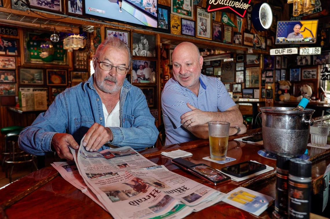 Long-time customers Steve Pougal of Kendall and Carlos Saque of Coral Gables enjoy a drink at the bar at Duffy’s Tavern in Miami.