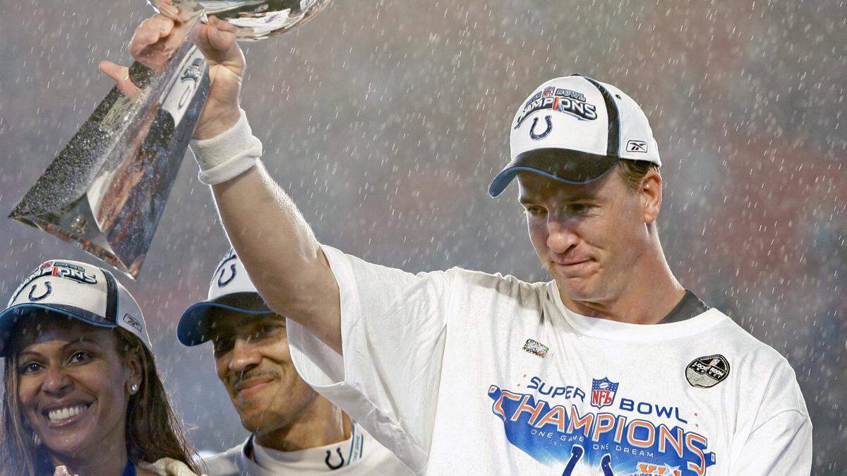 Indianapolis Colts quarterback Peyton Manning (18) celebrates with the championship trophy. At left is coach Tony Dungy.