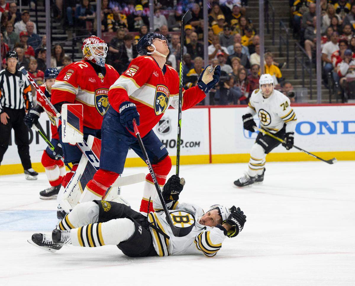 Boston Bruins left wing Brad Marchand (63) hits Florida Panthers defenseman Niko Mikkola (77) with his stick during the first period of a game on Tuesday, March 26, 2024, at Amerant Bank Arena in Sunrise, Fla.