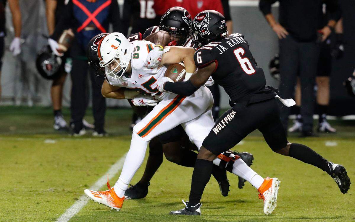 Miami tight end Will Mallory (85) is tackled by N.C. State safety Jakeen Harris (6), Tyler Baker-Williams (13) and Cecil Powell (4) during the first half of N.C. States game against Miami at Carter-Finley Stadium in Raleigh, N.C., Friday, Nov. 6, 2020.