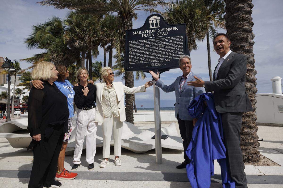 Left to right: Dr. Lynette Long, Bonnie Stoll, Chris Evert, Diana Nyad, Commissioner Steven Glassman, and Mayor Dean Trantalis unveil a street marker on Las Olas named after Nyad, the only person to swim from Cuba to Florida without a shark cage, on Thursday, Nov. 6, 2025, at Las Olas Oceanside Park in Fort Lauderdale, Fla.