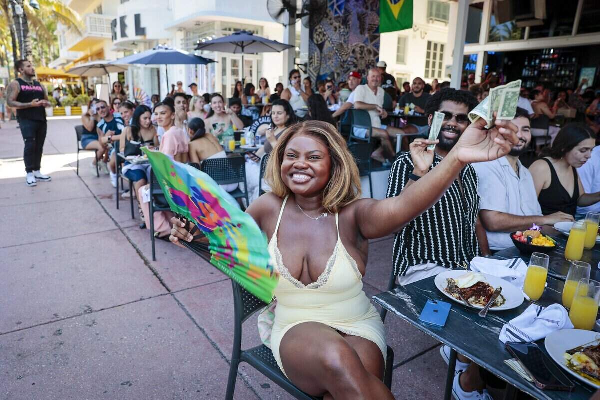 A Palace patron celebrating her birthday, center, extend her hand as she tries to tip for the performance by “Oscar G.”The Palace, an LGBTQ + friendly bar and restaurant, is known for its high-energy weekend drag brunches, where performers entertain guests with choreographed dances, lip-syncs and audience interaction. The scene was photographed on Sunday, June 28, 2026, in Miami Beach, Fla.
