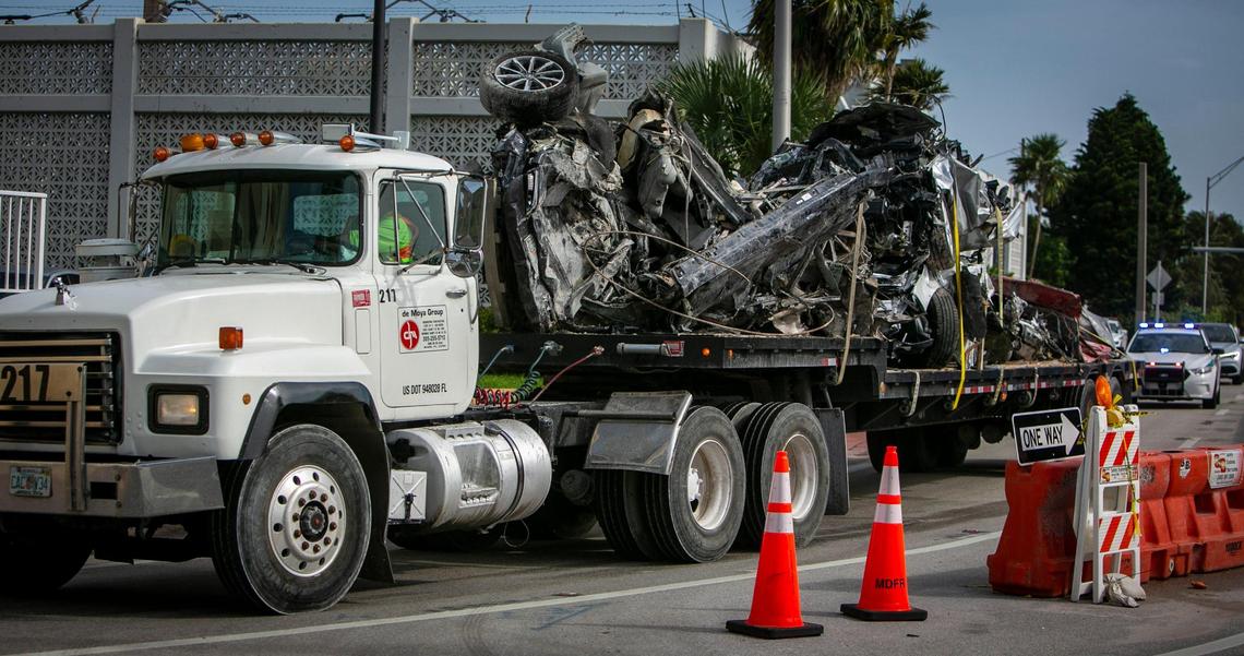 A truck carrying crushed vehicles drives south on Harding Avenue away from the Champlain Towers South site in Surfside on Tuesday, July 13, 2021. The debris came from the site of the collapse.