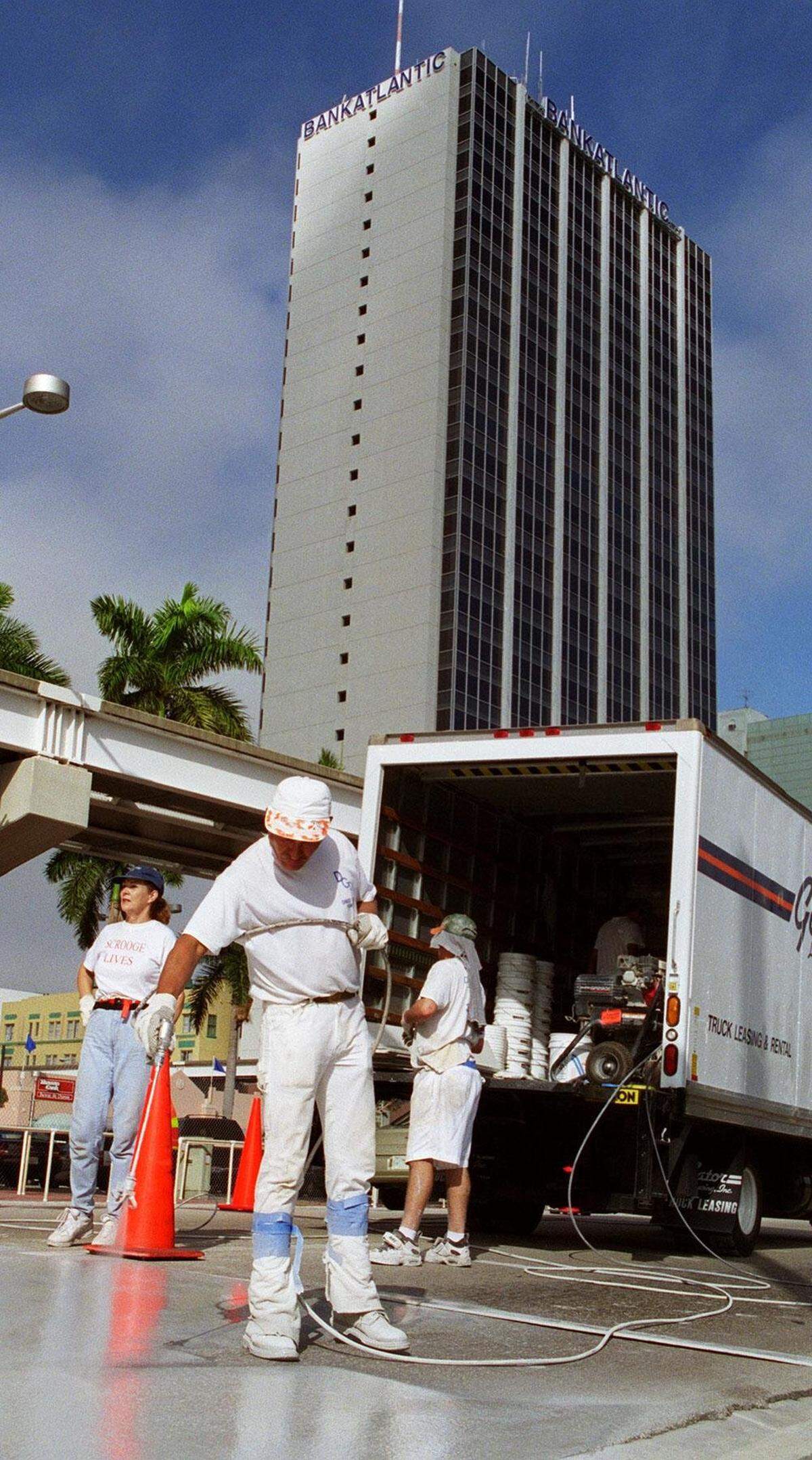In 1998, crews apply a temporary reflective material to Biscayne Boulevard, at the intersection of Flagler Street, in preparation for the New Years Eve Orange Bowl Parade. The material is a “secret formula” designed to reflect the colored lights used to illuminate the parade.