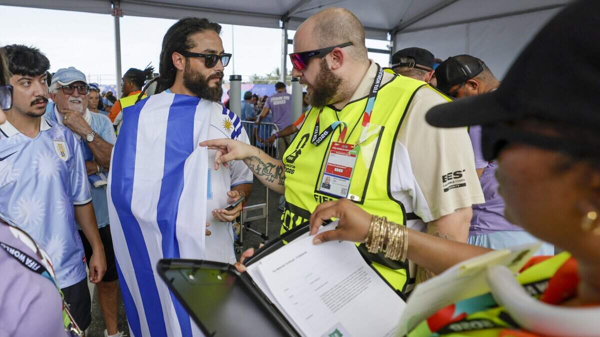 Christopher Noria is stopped by security to check on the size of the flag permitted that he is carrying as he enters the gates for Uruguay against Saudi Arabia FIFA World Cup opening match at Miami Stadium on Monday, June 15, 2026.