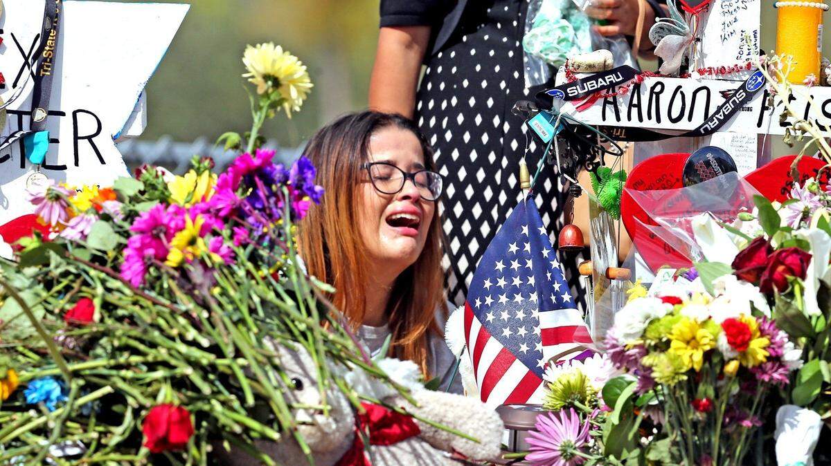 Former Marjory Stoneman Douglas High School student Ariana Gonzalez weeps at the cross of slain Douglas coach Aaron Feis, nine days after 17 students and teachers were killed at the school on Feb. 14, 2018.
