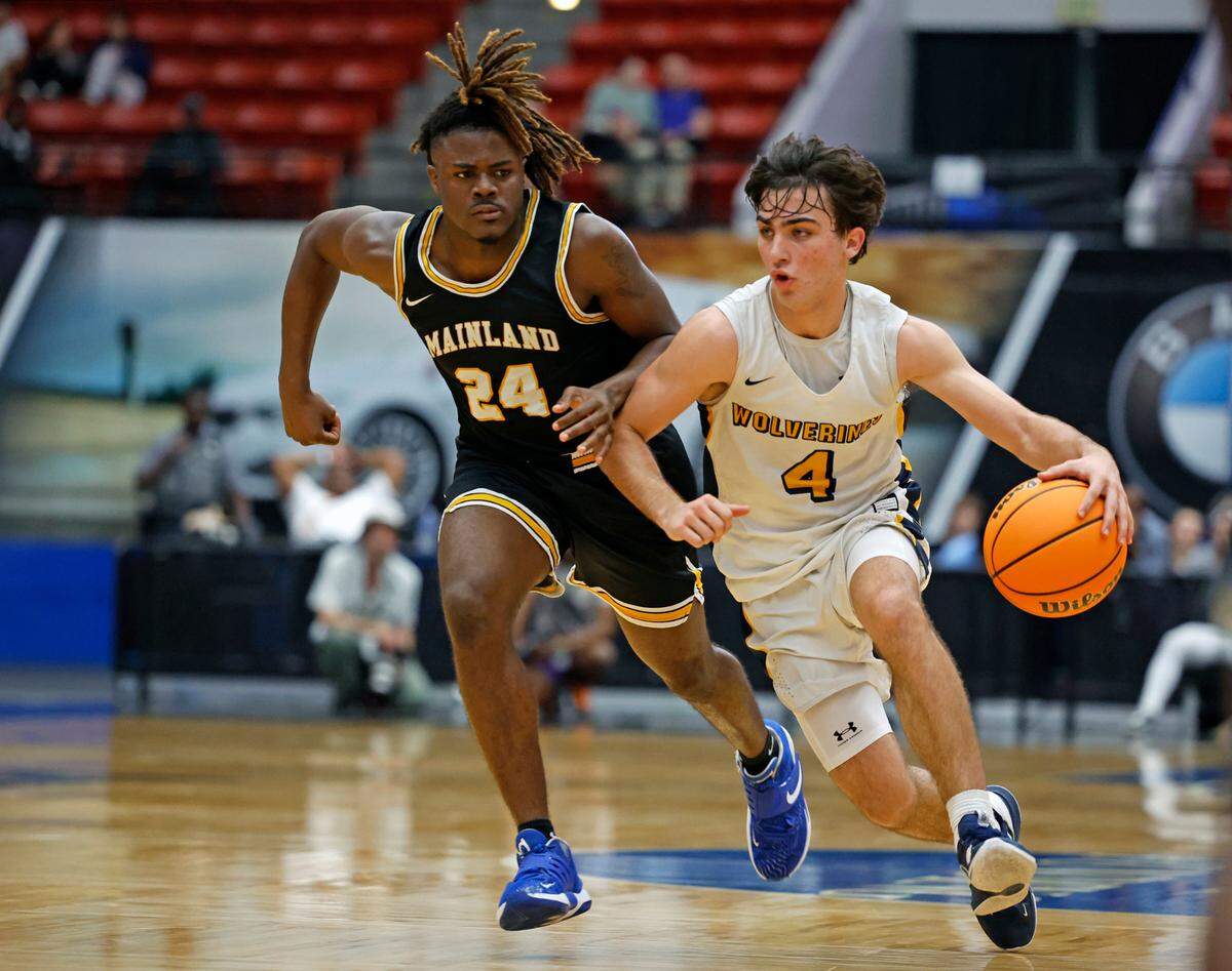 Belen Jesuit’s Javier Rosell (4) controls the ball as Ajai Harrell (24) gives chase in the FHSAA boys basketball Class 5A State Championship at the RP Funding Center in Lakeland, Florida on Saturday, March 4, 2023.