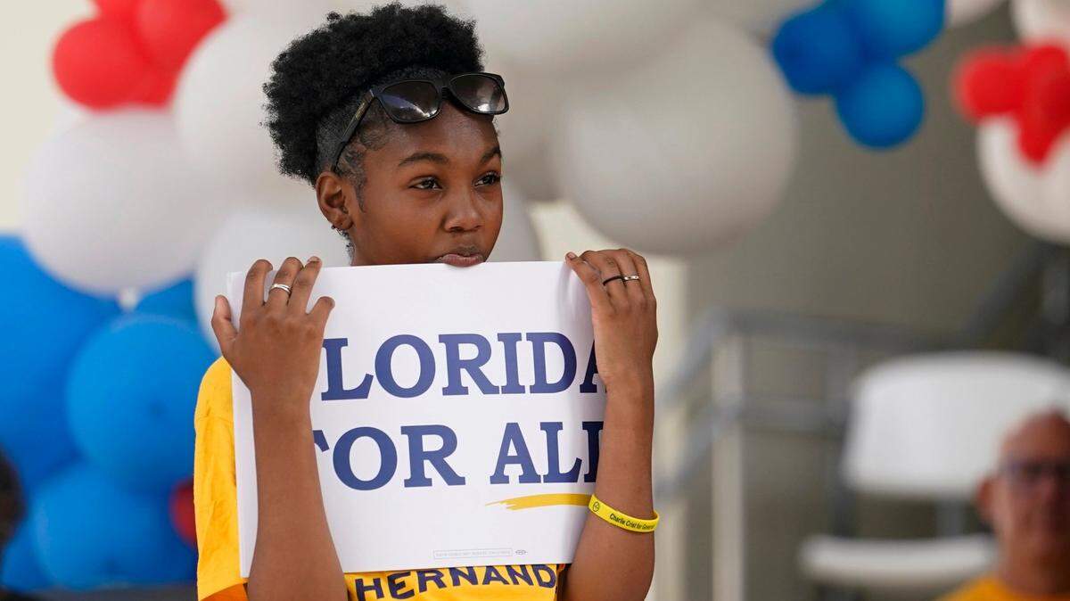 Mia Johnson, 13, holds a Florida for All sign during an event for Democratic candidate for Florida governor Charlie Crist at an early voting location, Sunday, Nov. 6, 2022, in Miami. (AP Photo/Lynne Sladky)