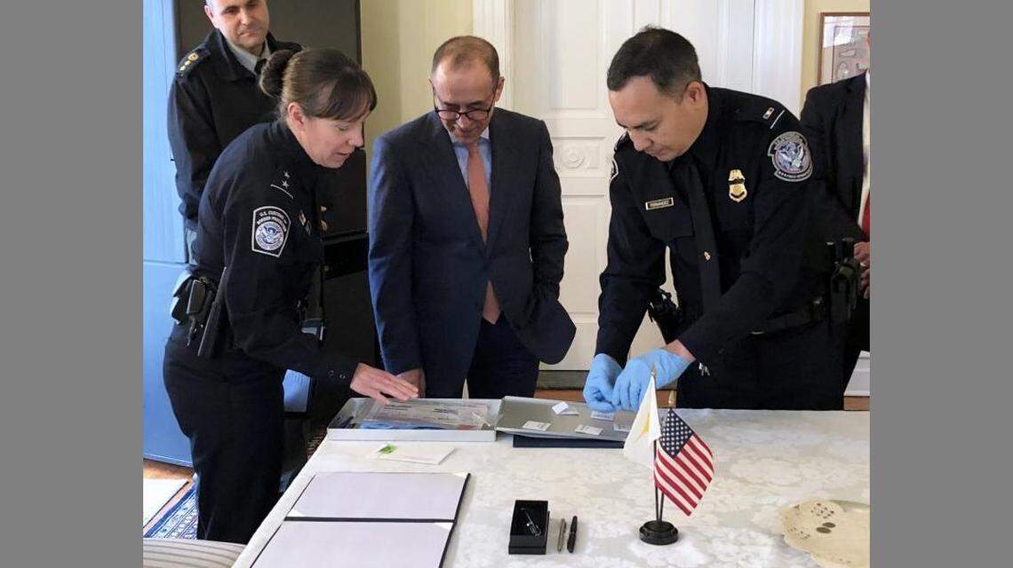 Casey Durst, with Customs and Border Patrol, (left) and Cyprus Ambassador Marios Lyssiotis (center) examined the ancient coins from the Roman Empire.