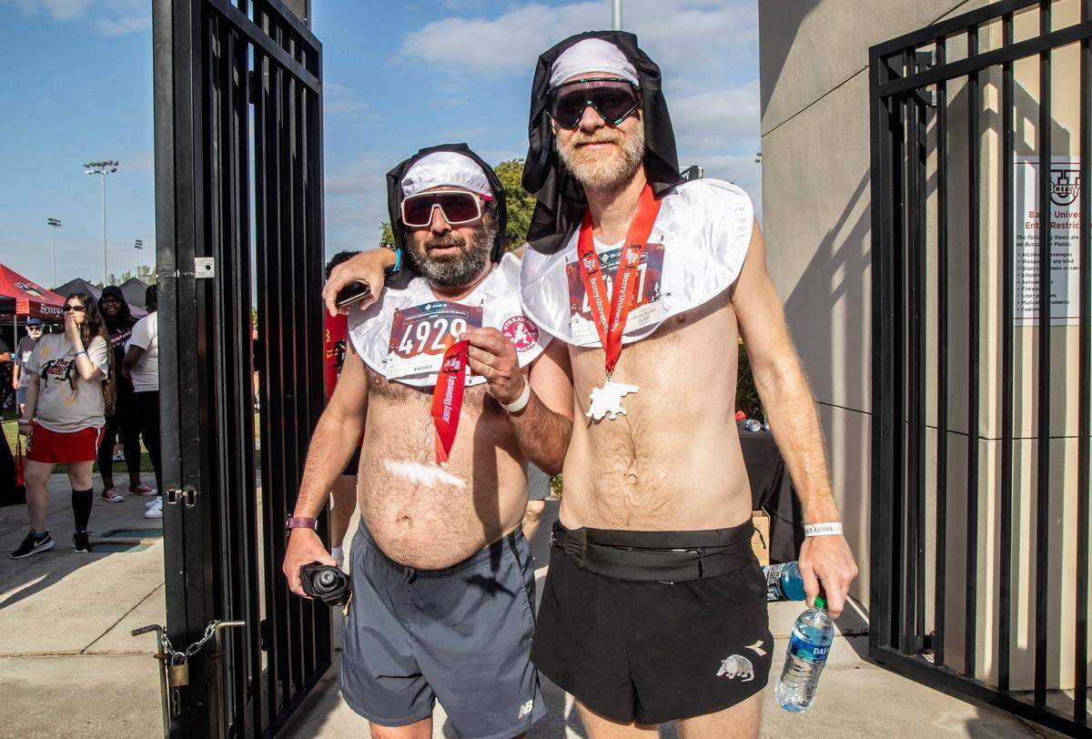 Runners Trevor Williams, left, of Ohio, and Tom Lefner (winner of the 8K run) of Pennsylvania, (wearing nuns habits), posed after running the Barry University 8K Nun Run on Saturday April 9, 2022. Both are with Hoof Hearted Brewing in Ohio, and are visiting Miami for a beer brewing event.