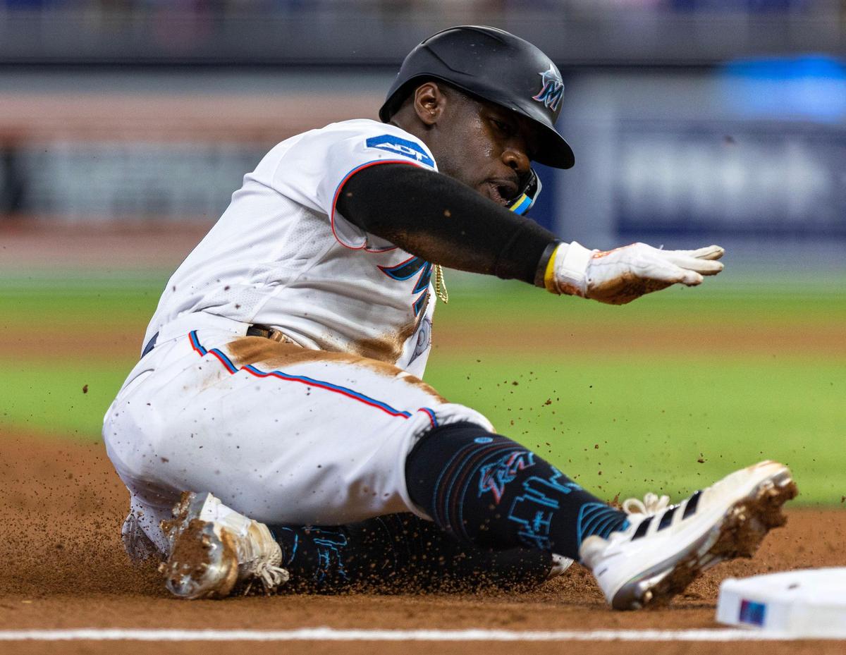 Miami Marlins base runner Jonathan Davis (49) slides into third base during the third inning of an MLB game against the San Diego Padres at loanDepot park in the Little Havana neighborhood of Miami, Florida, on Thursday, June 1, 2023.