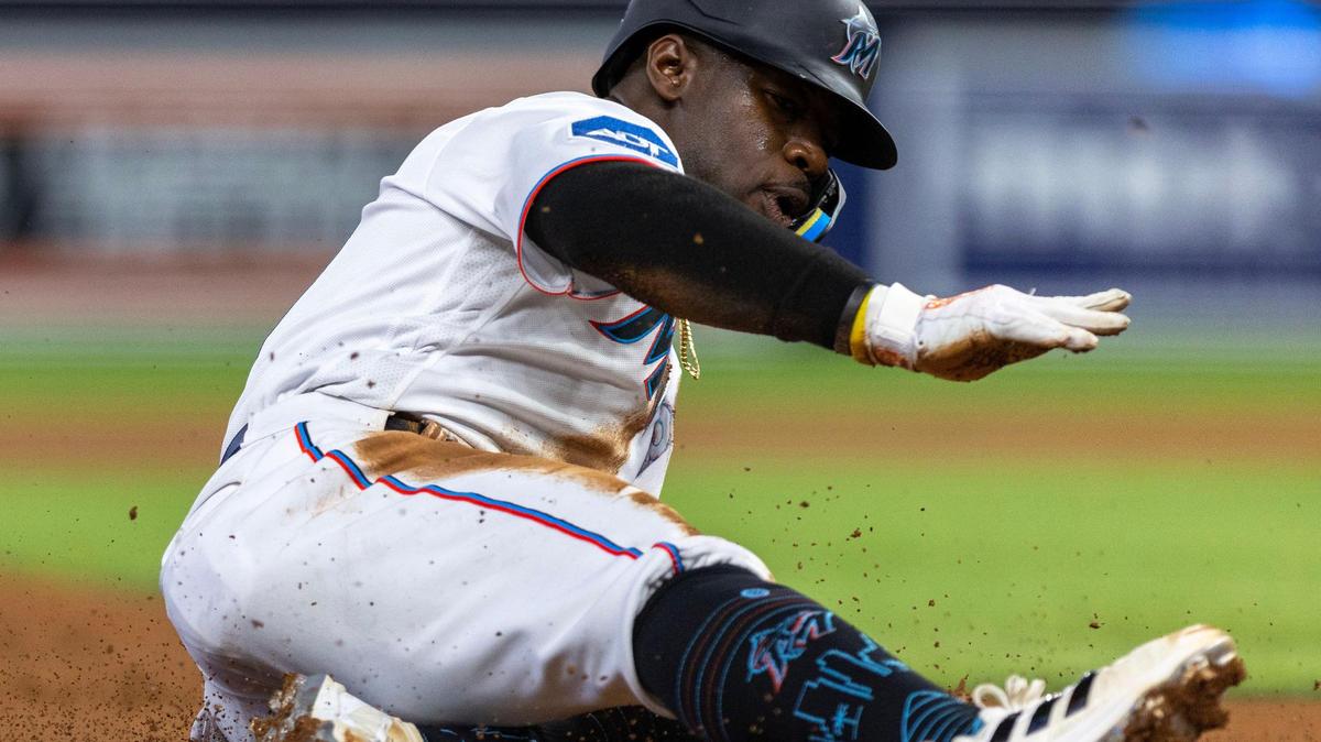 Miami Marlins base runner Jonathan Davis (49) slides into third base during the third inning of an MLB game against the San Diego Padres at loanDepot park in Miami on Thursday, June 1, 2023.