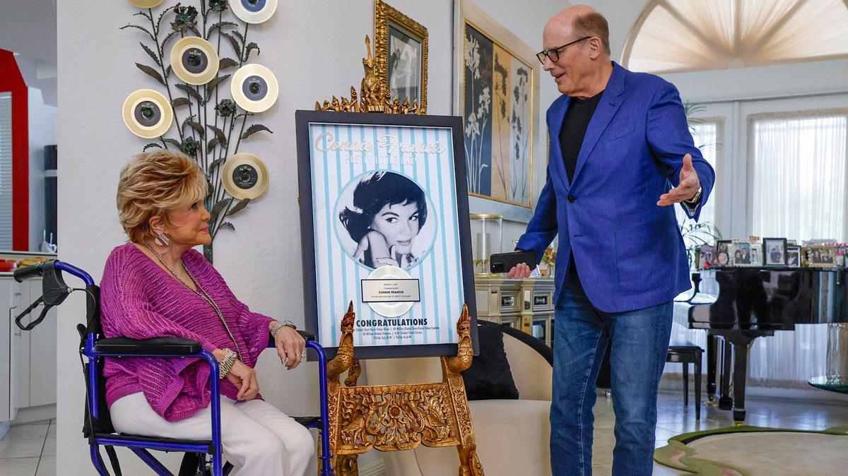 UMe Universal Music Group president and CEO Bruce Resnikoff presents a plaque to Connie Francis at her home in Parkland, Florida on Friday, June 6, 2025. They are celebrating the recent viral success of her 1962 song “Pretty Little Baby” on TikTok. Francis was a popular American pop singer from 1957 to 1964.