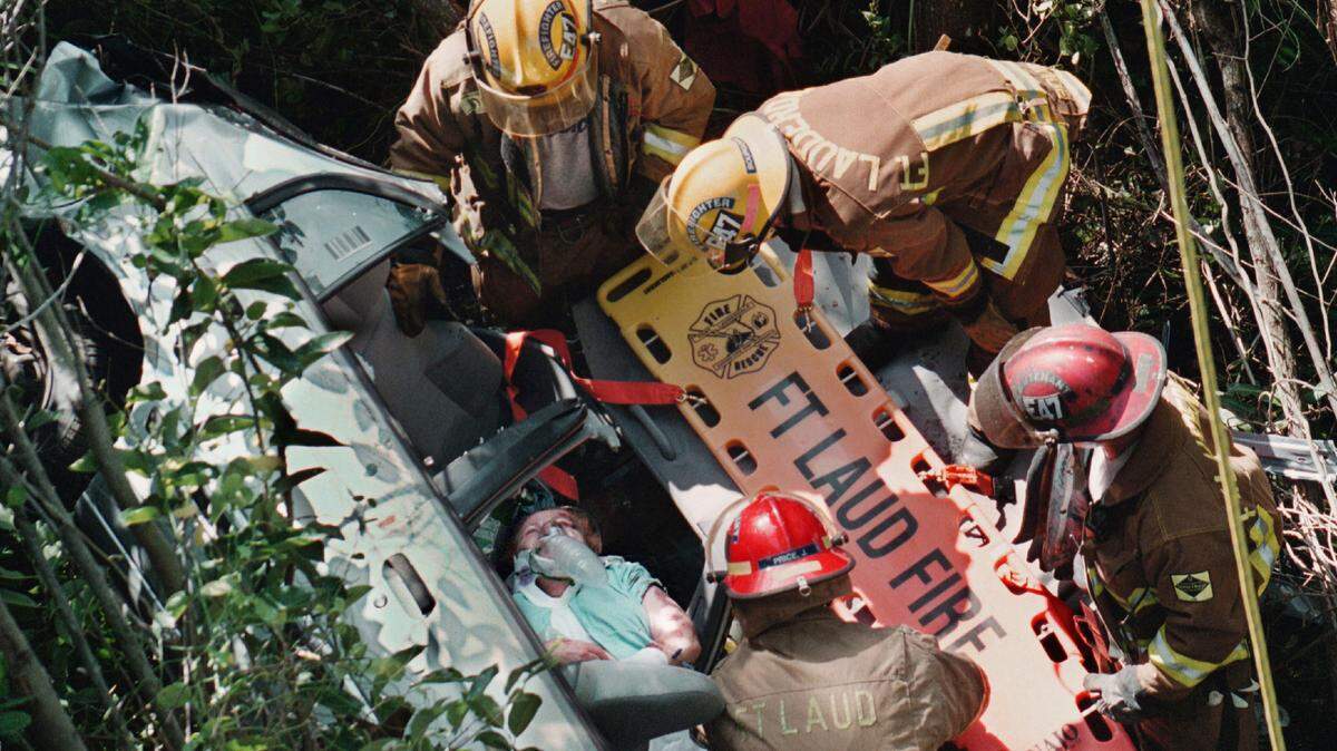 Tillie Tooter, 83, of Pembroke Pines, is about to be loaded on a back board along eastbound Interstate 595, east of U.S. 441. Tooter had been missing since early Saturday, when she was on her way to Fort Lauderdale-Hollywood International Airport to pick up her granddaughter, arriving by jet. Tooter’s Toyota car went over the retaining wall, center, and fell 40 to 50 feet into mangroves and muck. She was conscious when Fort Lauderdale Fire-Rescue firefighter paramedics got to her.