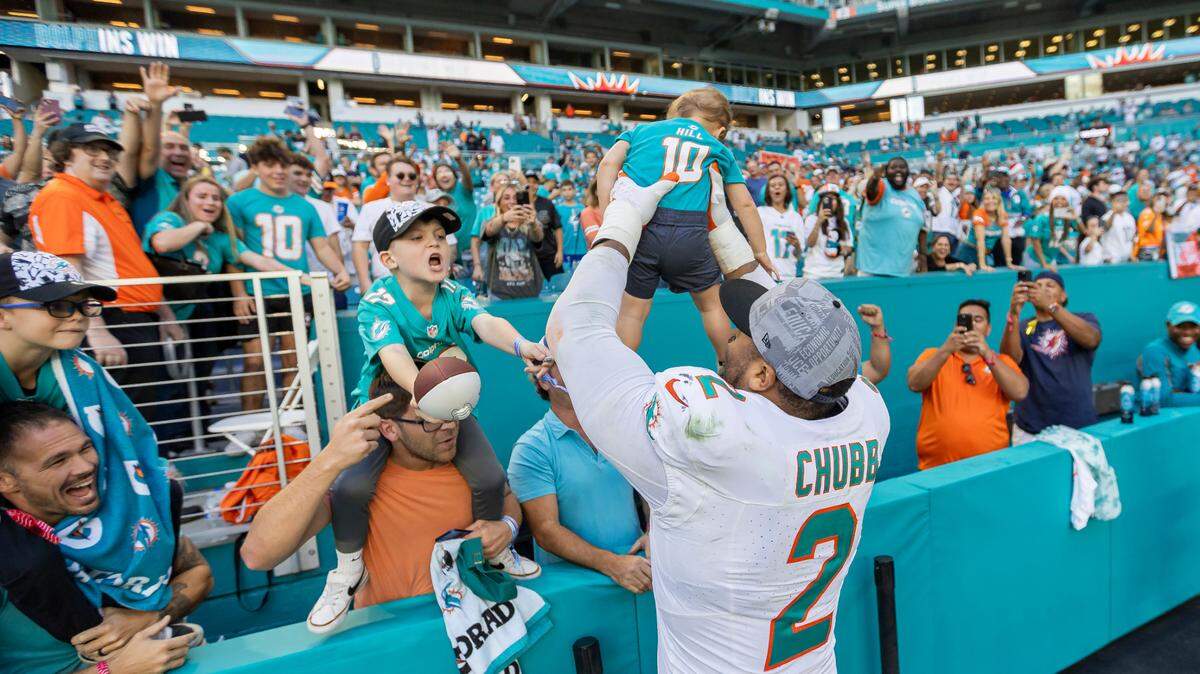Miami Dolphins linebacker Bradley Chubb (2) holds a baby after defeating the New York Jets in their NFL game at Hard Rock Stadium on Sunday, Dec. 17, 2023, in Miami Gardens, Fla.