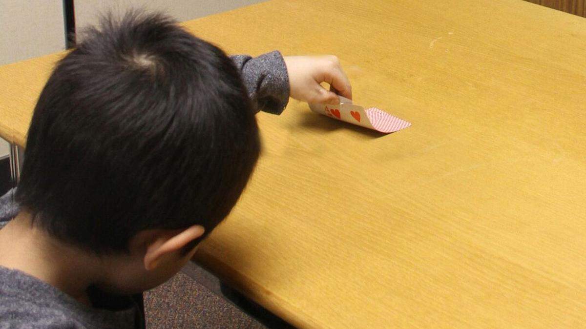 A child peeks at a hidden card when an adult leaves the room and later lies about not peeking during 2016 research into how young children start to lie at the University of Toronto in Toronto. Scientists say we all lie, but there are steps you can take to minimize how often a child lies, parenting experts say.