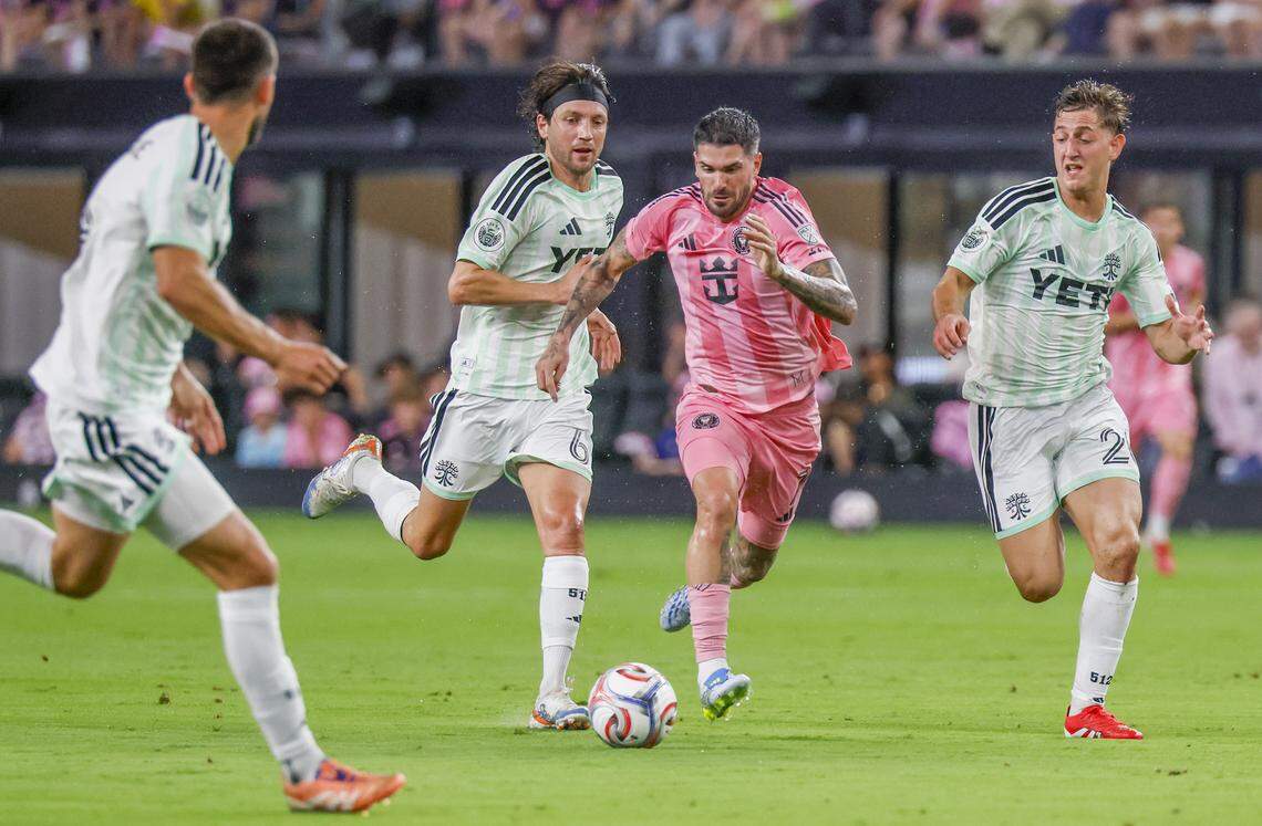 Inter Miami CF midfielder Rodrigo de Paul (7) kicks the soccer ball as Austin FC midfielder Ilie Sánchez (6) and forward Christian Ramírez (21) give chase during the first half of their MLS match at Nu Stadium in Miami Freedom Park on Saturday, April 4, 2026, in Miami, Florida.