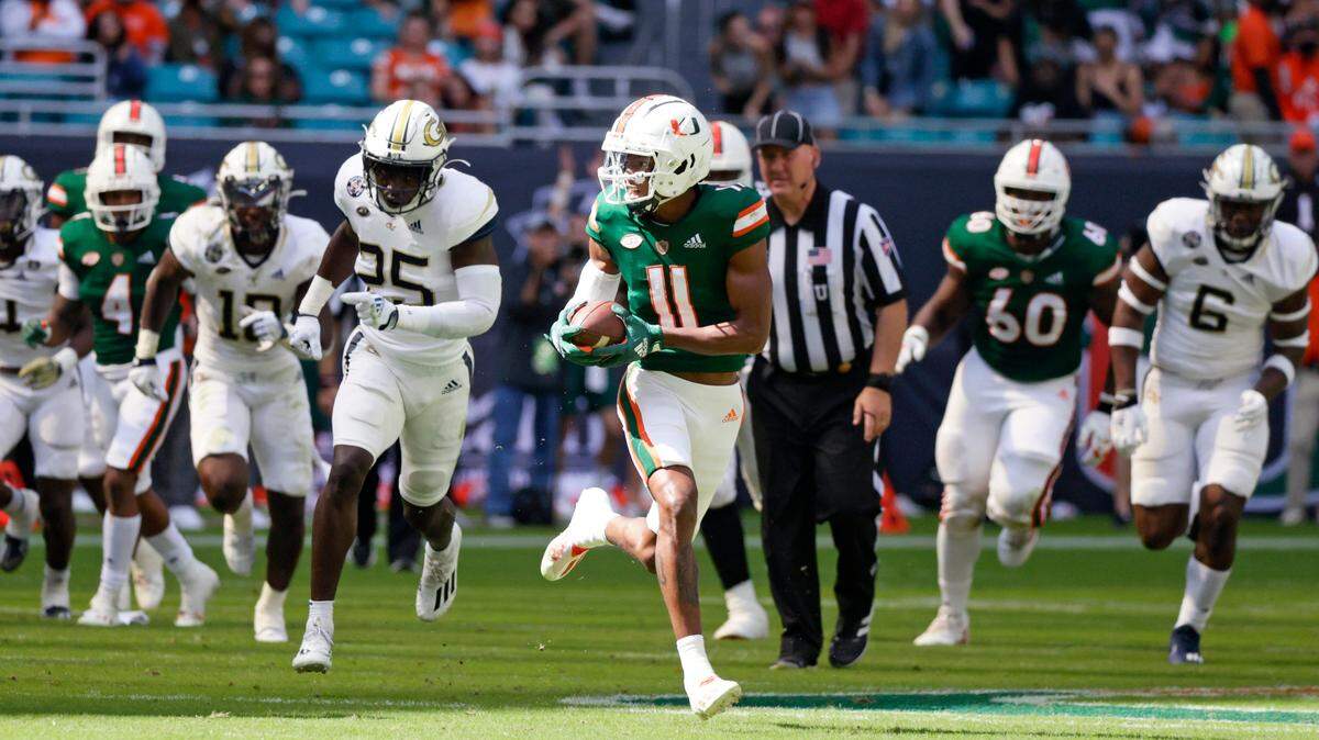 Miami Hurricanes wide receiver Charleston Rambo (11) runs with the football against the Georgia Tech Yellow Jackets during the first quarter of their ACC football game at Hard Rock Stadium on Saturday, November 6, 2021 in Miami Gardens, Florida.