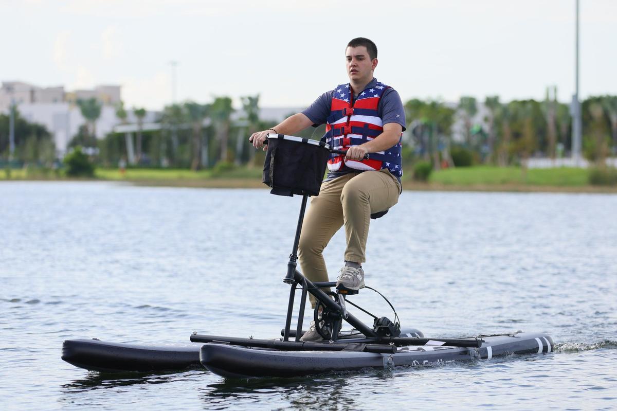 Fabrizio Prato, de 24 años, maneja bicicleta acuática en el lago de la recién inaugurada parte este del Doral Central Park en 3005 NW 92nd Ave. en Doral, Florida, el lunes 26 de agosto de 2024.