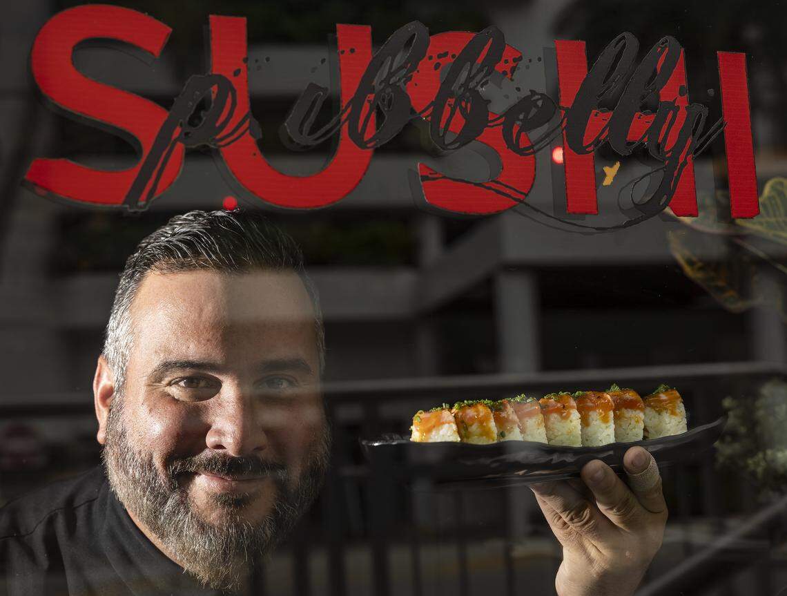 Chef Jose Mendin holds a Sake Aburi Roll at his restaurant, Pubbelly Sushi, on Thursday, Sept. 18, 2025, in Miami Beach, Fla. Mendin, who is Puerto Rican, is celebrating the restaurant's 15th anniversary. The roll consists of kanikama, seared salmon, yuzu miso, truffle oil and shichimi.