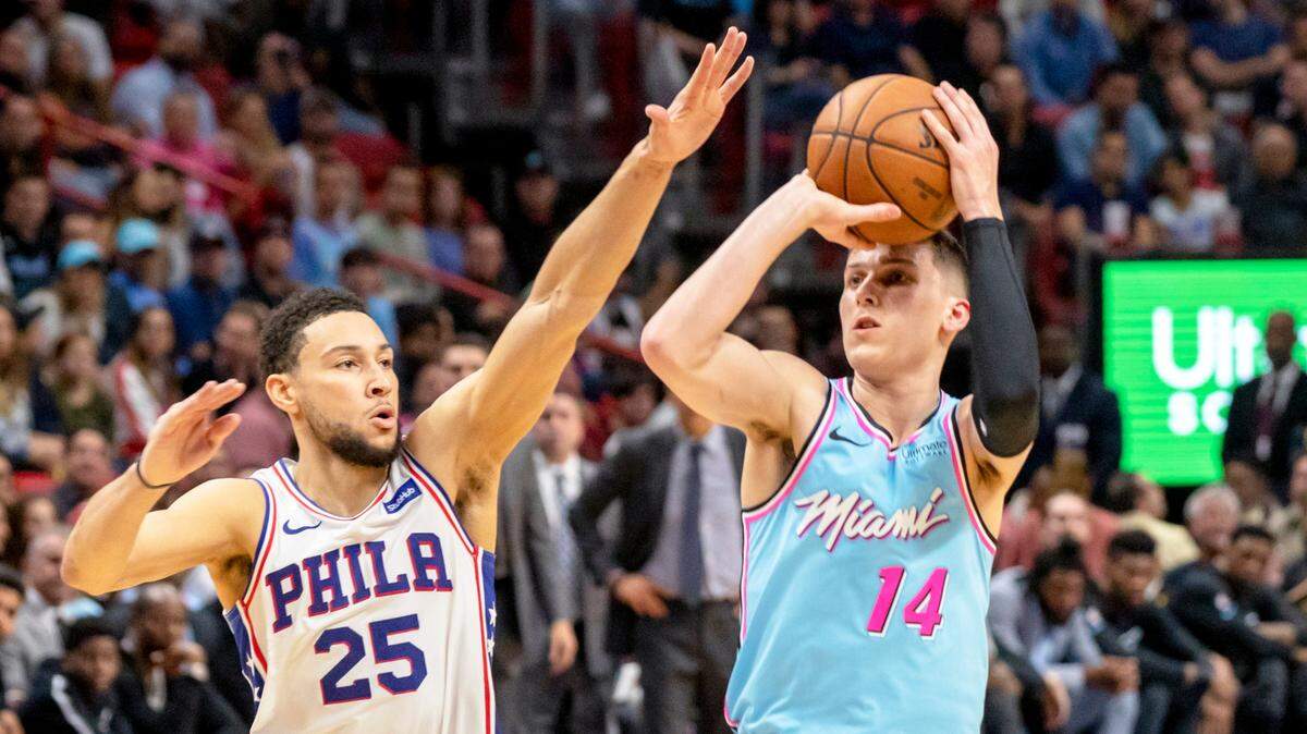  Tyler Herro, (14) autor de un espectacular triple para el Heat, tira al aro ante la marca del jugador de los 76ers Ben Simmons (25) este sábado 28 de diciembre en el AmericanAirlines Arena.