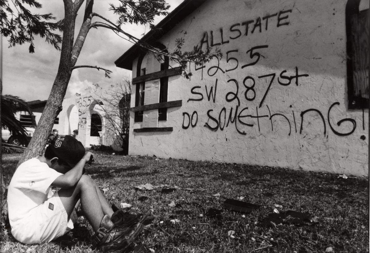Charles Trainor Jr., Miami Herald Staff - Hurricane Andrew - 8/27/1992 - Richard Colon, 11, sits by a tree at his house in South Miami-Dade, on Aug. 27, 1992. The family has not seen any officials or help since the storm destroyed their home. They plead for help by writing on their walls. Andrew made landfall on Aug. 24.