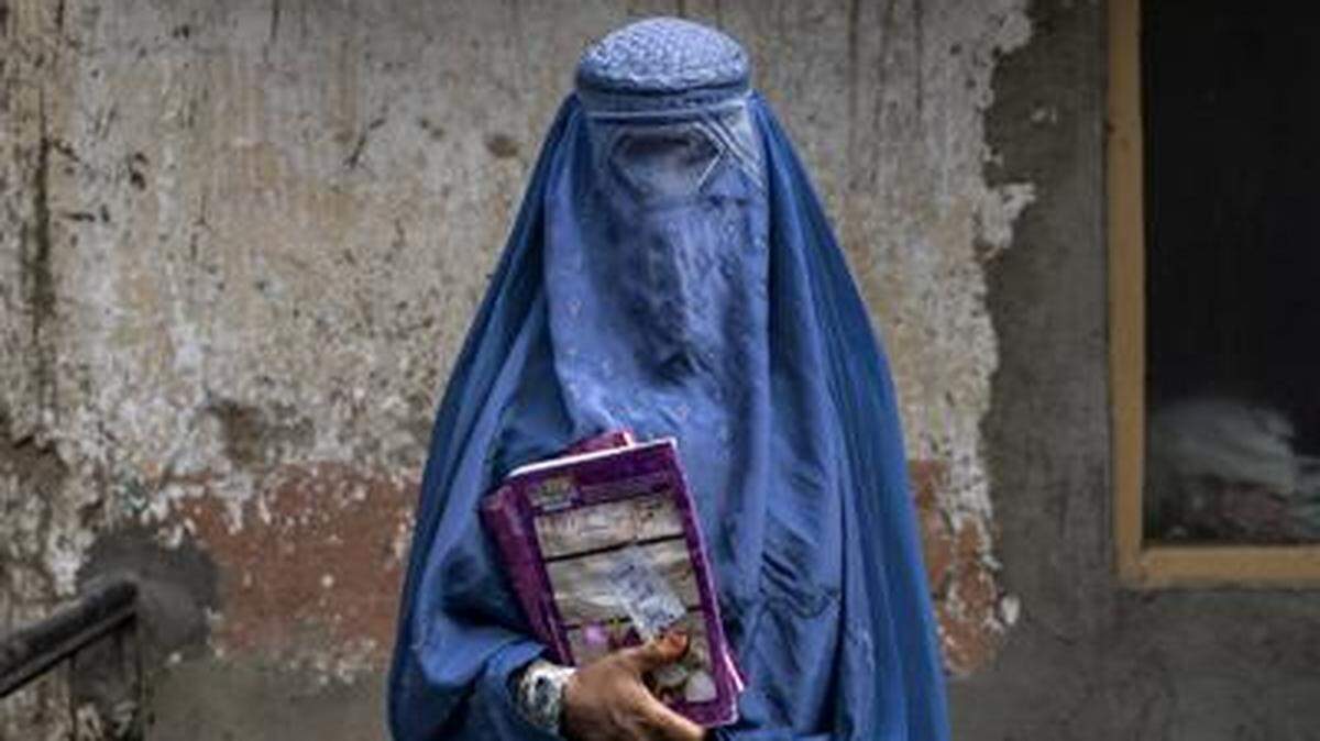 Arefeh, una mujer afgana de 40 años, sale de una escuela clandestina, en Kabul, Afganistán, en julio.
