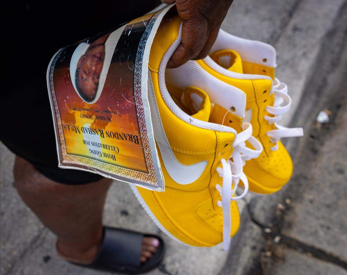 Lasonja Mills Vandyke, mother of 16-year-old Brandon Mills, holds the shoes that her son was wearing when he was killed in 2009. She returned on Aug. 27 for the first time to the site on 15th Avenue in Liberty City where he was killed. “His father used to call him yellow,” said Vandyke.
