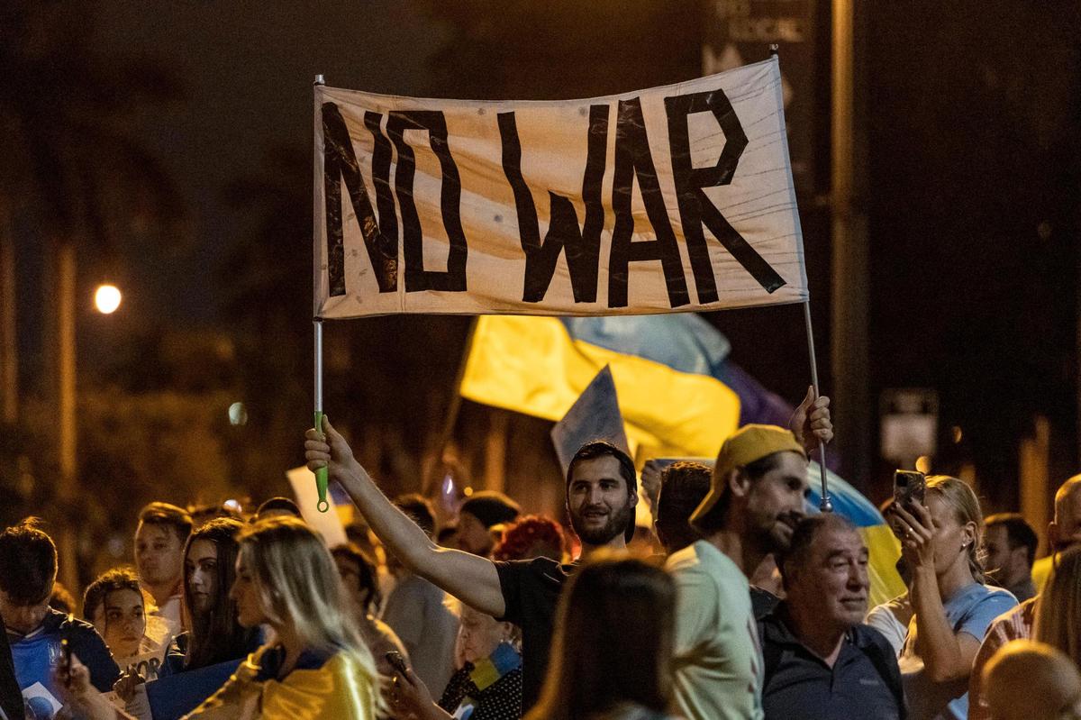 Hallandale Beach, Florida, February 24, 2022 - A man holds a No War banner in front of Hallandale Beach City Hall. Members of the Ukrainian and Russian communities in South Florida gathered in front of Hallandale Beach City Hall in support of the Ukraine after Russian forces invaded the country earlier in the day.