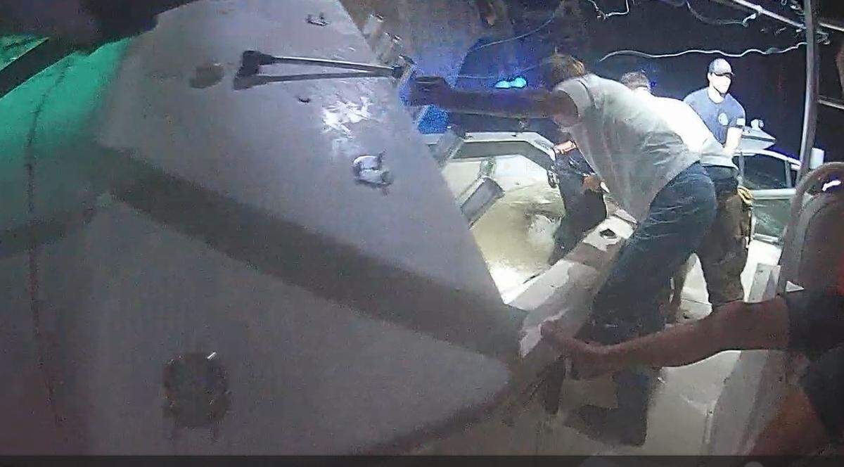 TowBoat US boat captain Kevin Freestone steadies his boat against a sinking Sea Hunter center console after it struck a Florida Keys bridge on Monday, July 8, 2024.