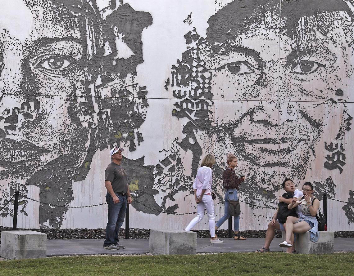 Local, national, and international visitors walk in front of a mural by artist Vhils at Wynwood Walls on Sunday, November 25, 2019.
