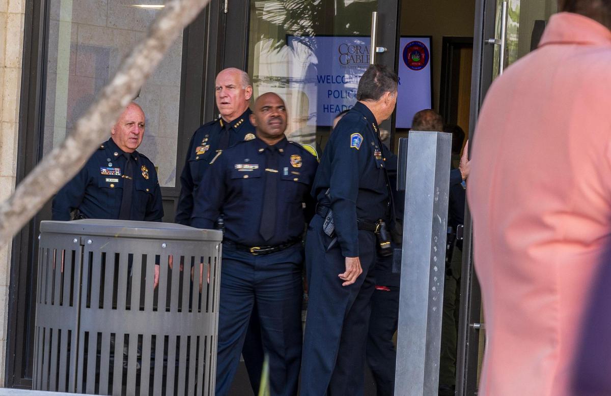 El jefe policial de Coral Gables, Edward James Hudak, Jr., habla y algunos agentes mientras un grupo de activistas protestaban afuera mientras se realizaba una reunión para discutir un acuerdo entre la ciudad de Coral Gables y el ICE el martes 11 de marzo de 2025.