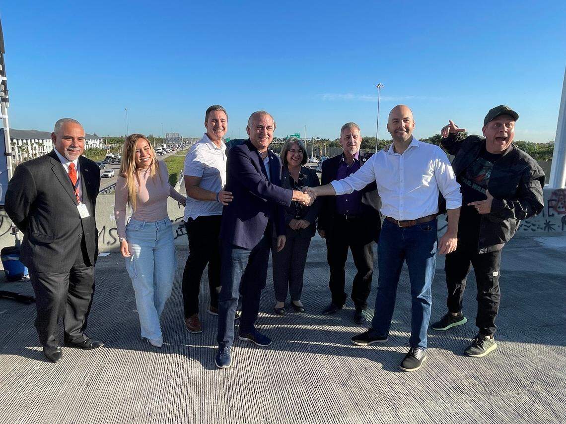 El alcalde de Hialeah, Esteban Bovo (Izq) estrecha la mano del alcalde de Miami Lakes, Manny Cid en el puente cerrado de 170 Street sobre la I-75, en una imagen del 4 de marzo de 2022.