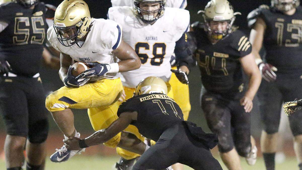 St. Thomas Aquinas Raiders’ running back Anthony Hankerson (22) jumps to escape a tackle during the football game against Western Wildcats on Friday, Nov. 1, 2019 at Western HS in Davie