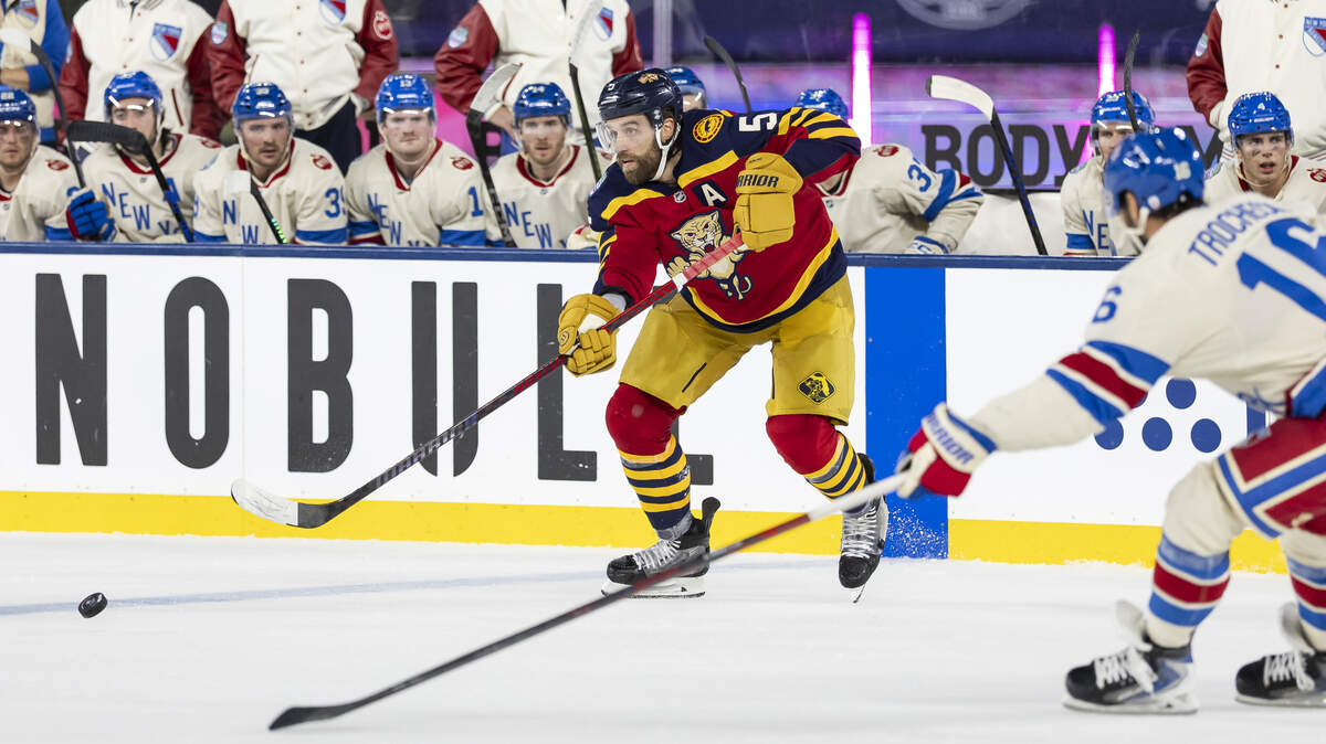 Florida Panthers defenseman Aaron Ekblad (5) looks to pass the puck as New York Rangers center Vincent Trocheck (16) defends in the third period of their Winter Classic outdoor hockey game at loanDepot park on Friday, Jan. 2, 2026, in Miami, Fla.