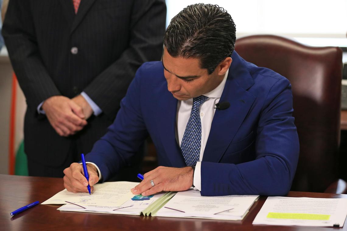 Miami Mayor Francis X. Suarez signs a document vetoing a rezoning of a sliver of land on the Brickell waterfront at Miami City Hall on Friday, August 2, 2019.
