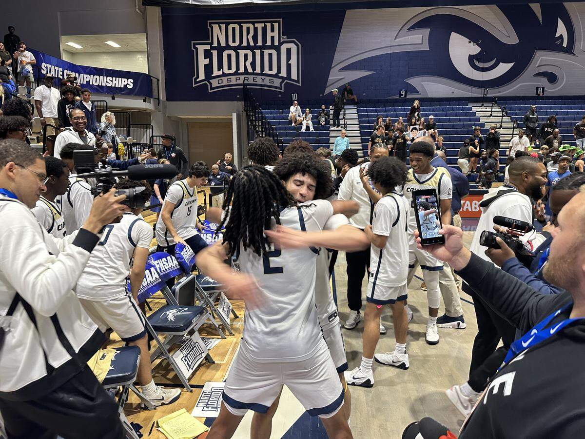 Calvary Christian's Cayden Daughtry and Kenneth Francis Jr. share a hug after they led the Eagles to the Class 3A state boys’ basketball championship on Wednesday night at UNF Arena in Jacksonville, Fla.