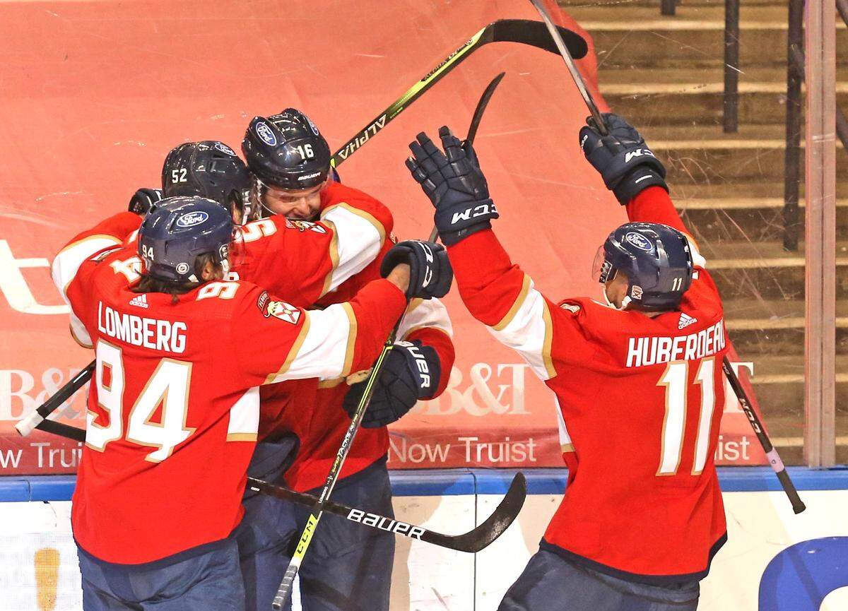 Florida Panthers players celebrate with Aleksander Barkov (16) after Barkov scored the winning goal in overtime as they defeat the Carolina Hurricanes at the BB&T Center in Sunrise, Florida, Saturday, April 24, 2021.